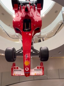 Ferrari Formula 1 car displayed upside down in a showroom, showcasing its sleek design.